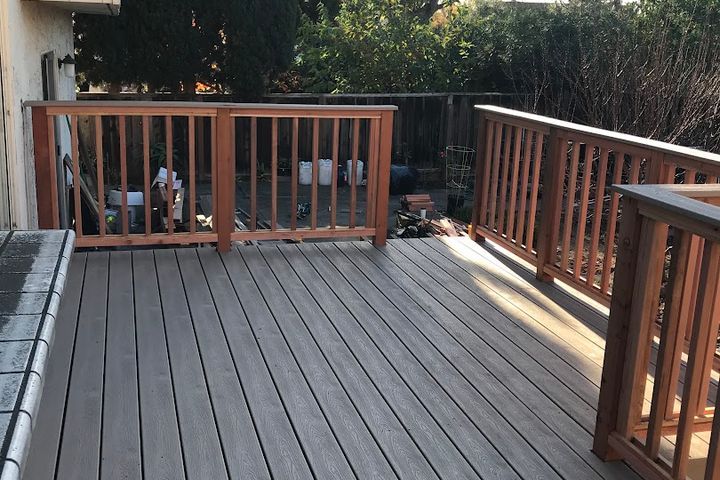 Completed backyard deck with composite boards and wood railings