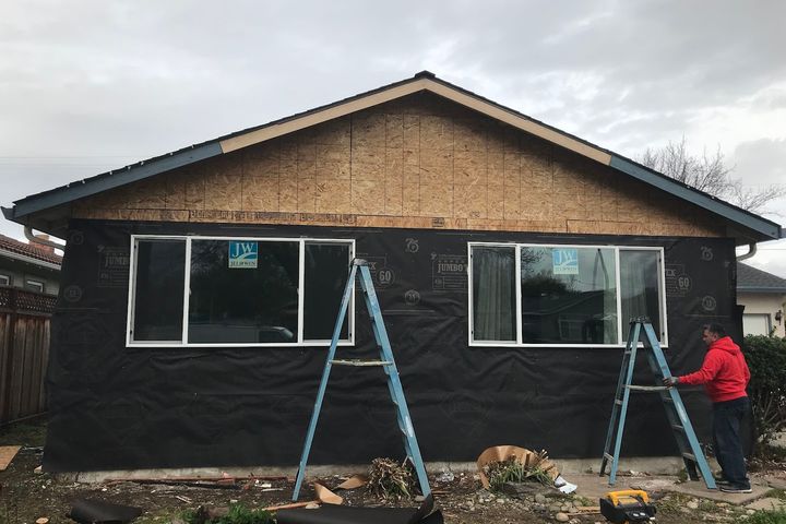 Home exterior under renovation with new windows and weather barrier