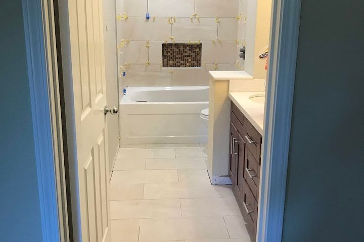 Small remodeled bathroom with vanity and tiled tub surround